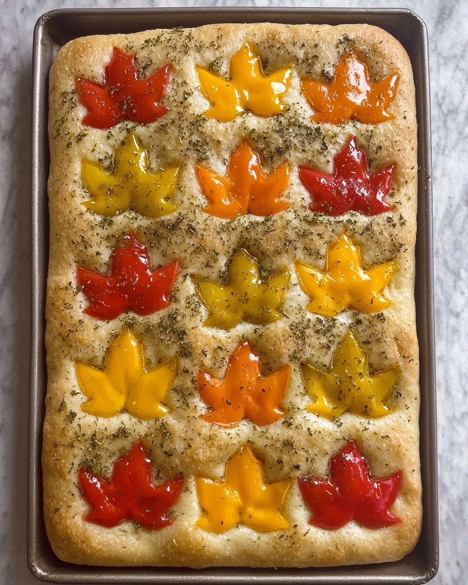 A golden brown focaccia bread with a textured surface is decorated with colorful bell pepper slices shaped like maple leaves. The leaves are scattered evenly across the bread, displaying vibrant shades of red, orange, and yellow with a glossy look. The bread has small dimples and is sprinkled with coarse salt and herbs, giving it a seasoned and inviting appearance. It rests on a wooden board over a white marbled textured surface. photo taken with an iphone --ar 4:5 --v 7
