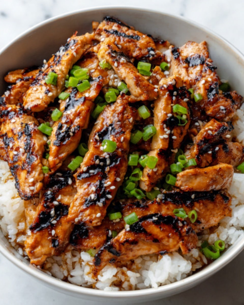 The image shows a white bowl filled with white rice at the bottom layer, which looks soft and fluffy. On top of the rice, there are many pieces of grilled chicken with a golden brown color and slightly charred marks, making them look juicy and flavorful. The chicken pieces are scattered evenly, and they are garnished with small pieces of bright green chopped spring onions and a sprinkle of white sesame seeds, adding texture and color contrast. The bowl sits on a white marbled surface, giving a clean and fresh look. photo taken with an iphone --ar 4:5 --v 7