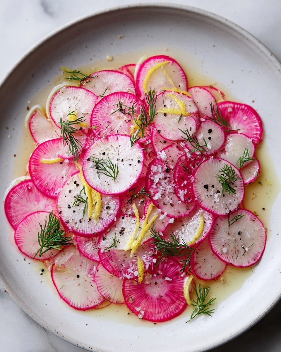 A white plate holds a thin layer of bright pink-edged radish slices spread evenly, showing their white centers with a slight pink tint near the edges. Scattered on top are small sprigs of fresh green dill, icy white salt crystals, and coarse black pepper dots that add contrast. Lemon wedges with yellow rinds peek through the radishes, adding color variation. A clear light dressing pools slightly beneath the radishes, giving a glossy texture. The plate sits on a white marbled surface, enhancing the fresh and clean look of the dish. photo taken with an iphone --ar 4:5 --v 7