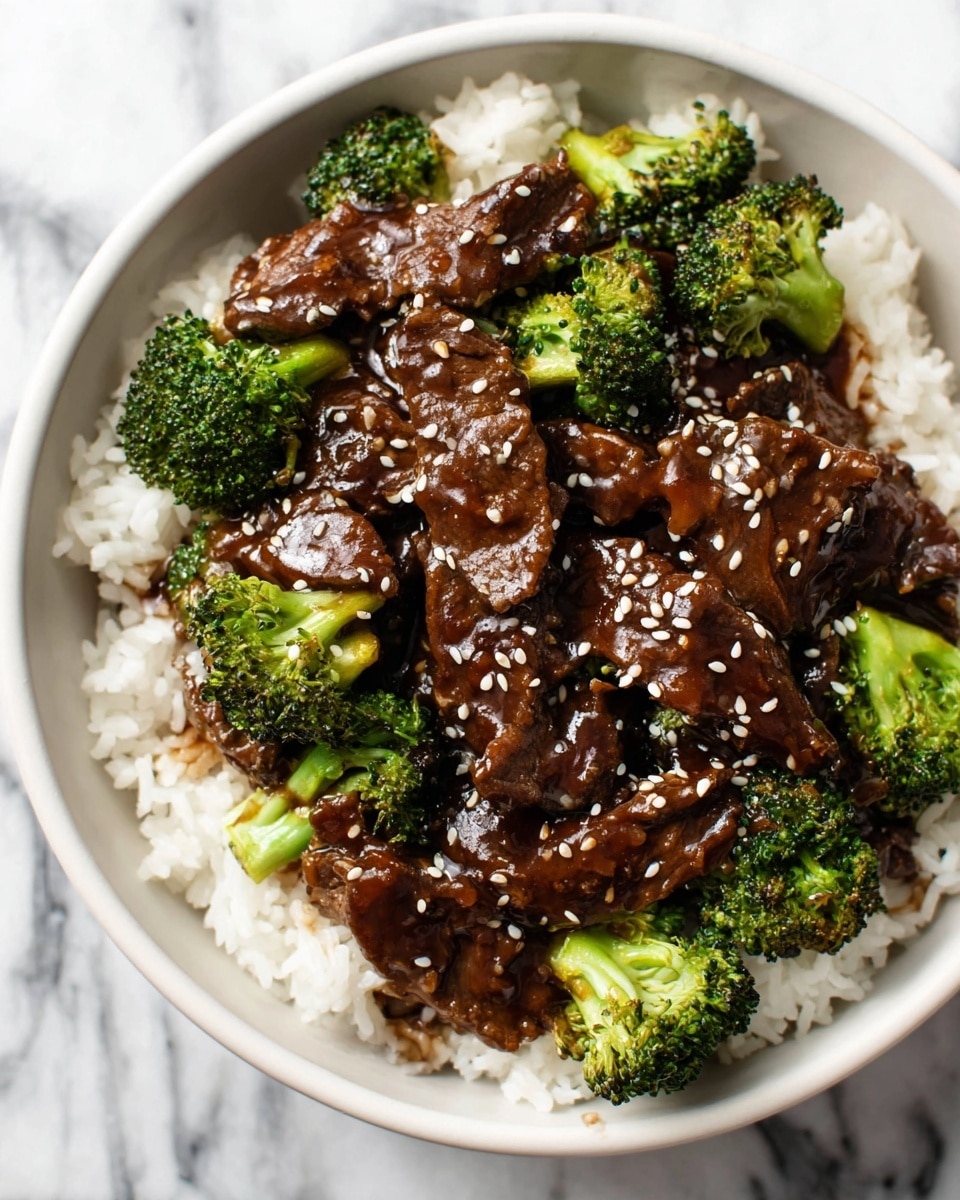 A bowl filled with a base layer of white cooked rice, topped with several pieces of dark brown beef coated in a glossy sauce. Scattered among the beef pieces are bright green broccoli florets, adding contrast and texture. The dish is sprinkled evenly with small white sesame seeds, enhancing its visual appeal, all served in a white bowl placed on a white marbled surface. photo taken with an iphone --ar 4:5 --v 7