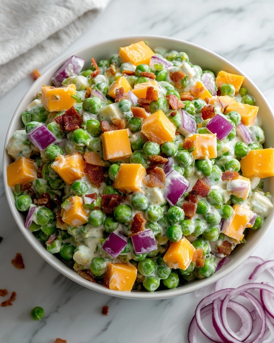 This image shows a close-up of a pea salad in a white bowl placed on a white marbled surface. The salad has three main layers: bright green peas forming most of the base, interspersed with small chunks of creamy white dressing coating the ingredients. Large cubes of orange cheddar cheese and purple-red diced onion pieces are scattered evenly throughout the salad, adding color and texture contrast. Small bits of crispy brown bacon are also mixed in, giving a slightly rough texture among the smooth peas and creamy dressing. Some slices of red onion rings are visible on the white marbled surface around the bowl. The photo taken with an iphone --ar 4:5 --v 7