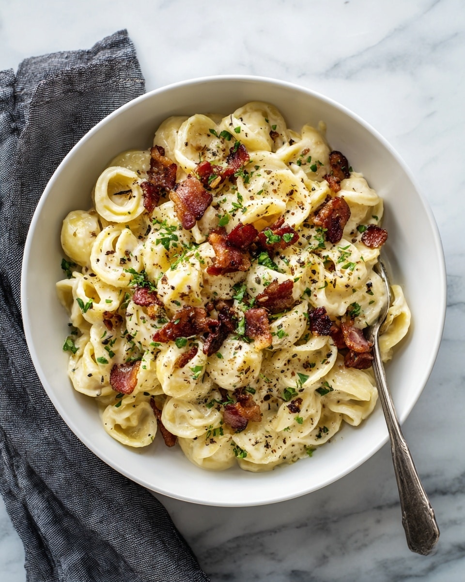This dish features a round white bowl filled with creamy pasta. The pasta is a light yellow color with a soft, smooth texture and shaped like short twists and tubes. Mixed throughout the pasta are several pieces of crispy brown bacon, adding contrast with their rough texture. Small green herbs are sprinkled over the top, along with cracks of black pepper. The bowl rests on a white marbled surface and is partially covered by a gray cloth napkin on the left side. photo taken with an iphone --ar 4:5 --v 7