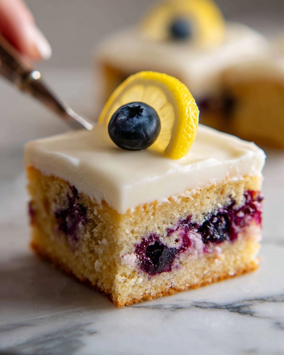 A square piece of blueberry cake with a light glaze covers the top evenly, giving it a shiny, smooth texture. The cake layer is golden brown with visible blueberries inside, creating purple spots throughout. On top of the glaze, there is a thin lemon slice and a single blueberry placed near the corner. The cake is on a white cooling rack set over a white marbled surface. A knife with some cake crumbs and glaze rests in the background. Photo taken with an iphone --ar 4:5 --v 7