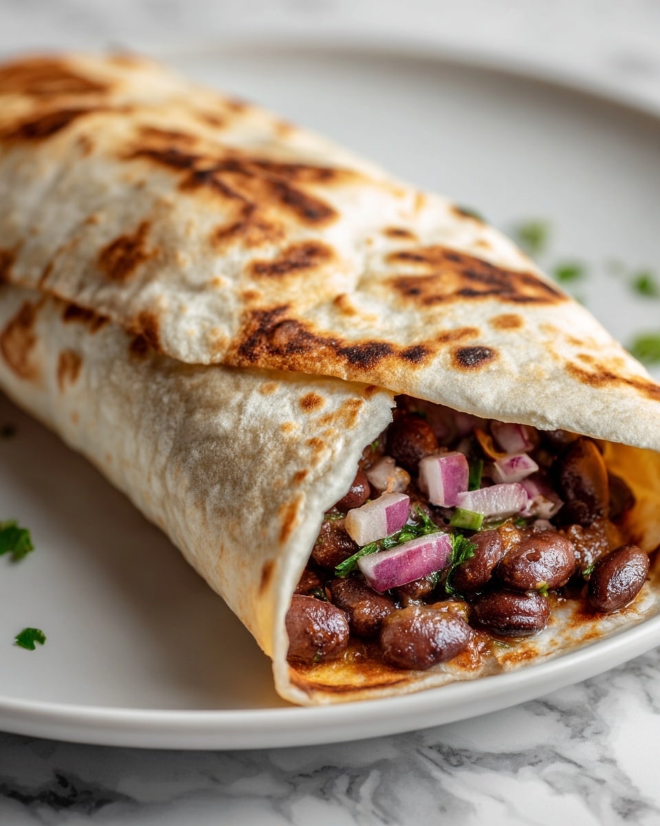 A close-up of a burrito cut in half, showing three clear layers inside: a soft white tortilla with light brown toasted spots wraps around a filling of dark black beans mixed with bright bits of pink onion, and some finely chopped green herbs and light orange sauce. The burrito rests on a smooth white plate, all placed on a white marbled background. The texture of the tortilla looks soft and slightly chewy, while the filling looks moist and chunky. Photo taken with an iphone --ar 4:5 --v 7