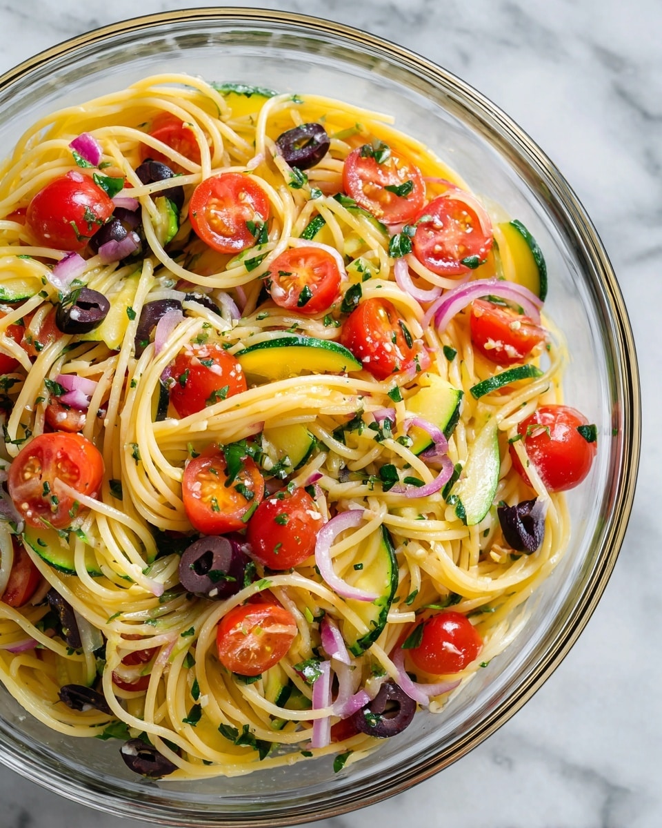 A clear glass bowl filled with spaghetti pasta mixed with bright red cherry tomatoes cut in halves, dark black olive slices, chopped green zucchini pieces, and thin strips of purple onion. The pasta strands are light yellow and twisted throughout the bowl, while the vegetables add vibrant color and texture in layered bits across the dish. The entire bowl sits on a white marbled surface, and the dish looks fresh and colorful. photo taken with an iphone --ar 4:5 --v 7