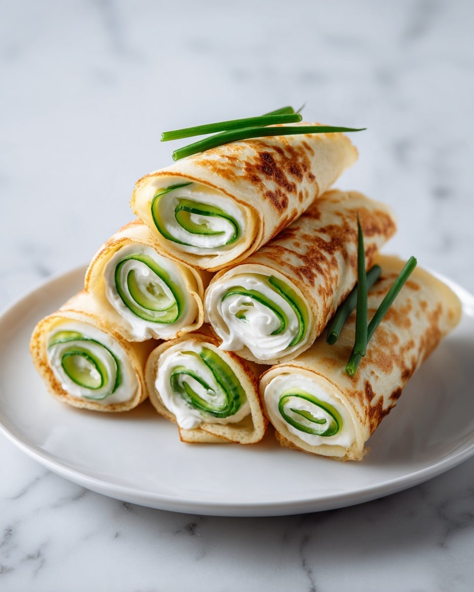 The image shows six rolled wraps placed on a white plate with a white marbled surface underneath, arranged in a close pile. Each wrap has three visible layers: the outer layer is a light beige flatbread with slight brown spots, the middle layer is a bright green cucumber sliced thinly, and the inner layer is a creamy white cheese spread. The wraps are neatly rolled, showing the spiral of the green cucumber and white cheese inside, and some green chive pieces stick out from the top of a few wraps. The lighting is soft, emphasizing the textures of the flatbread and the fresh cucumber. photo taken with an iphone --ar 4:5 --v 7