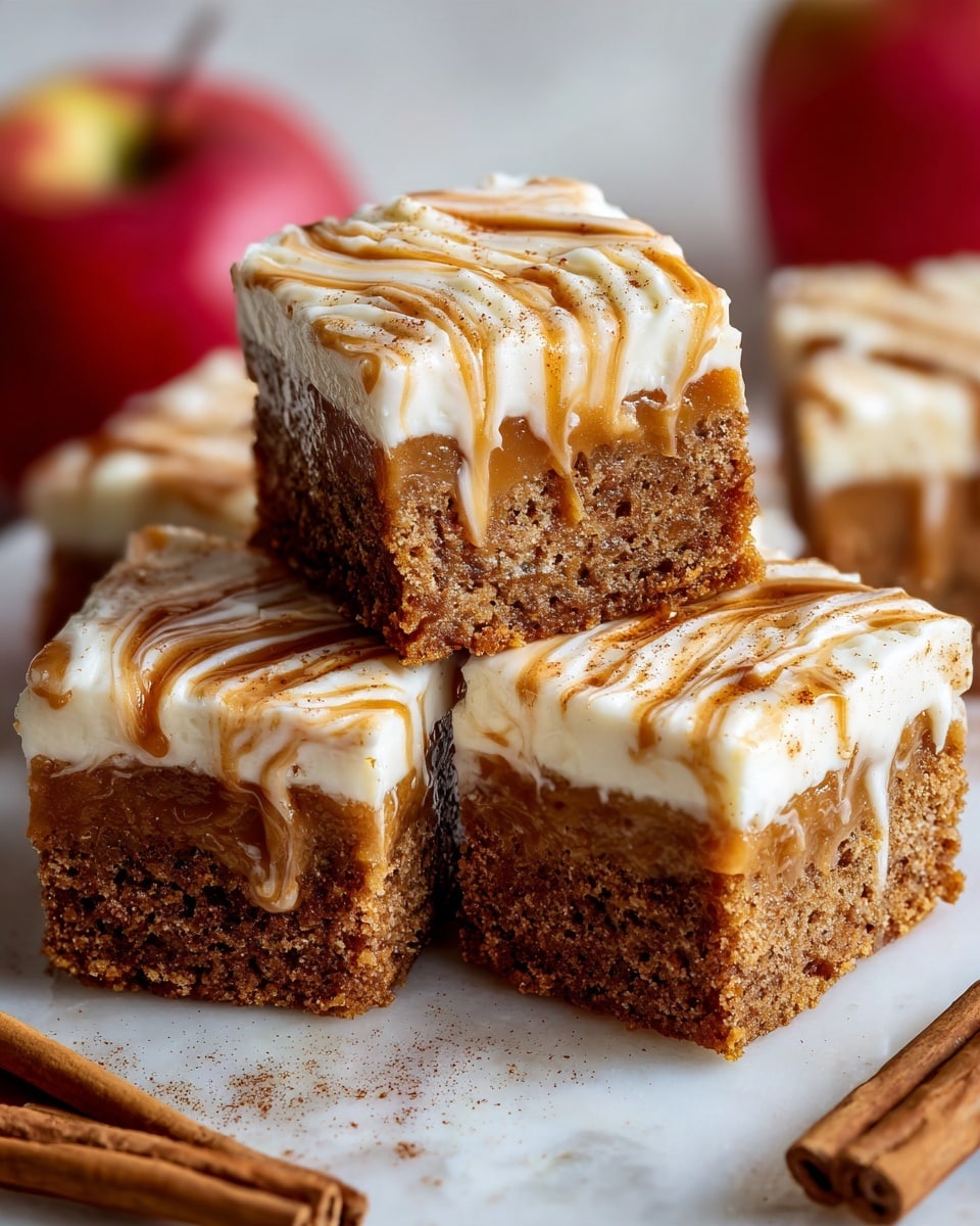 A close-up of square pieces of cake arranged closely together, each piece showing two visible layers: a thick, moist light brown base layer with a rough texture, and a smooth cream-colored top layer swirled with caramel-colored streaks, slightly dripping over the edge. Behind the cake pieces, whole deep red apples are partially visible, and the scene is set on a white marbled surface with cinnamon sticks and star anise scattered around. photo taken with an iphone --ar 4:5 --v 7