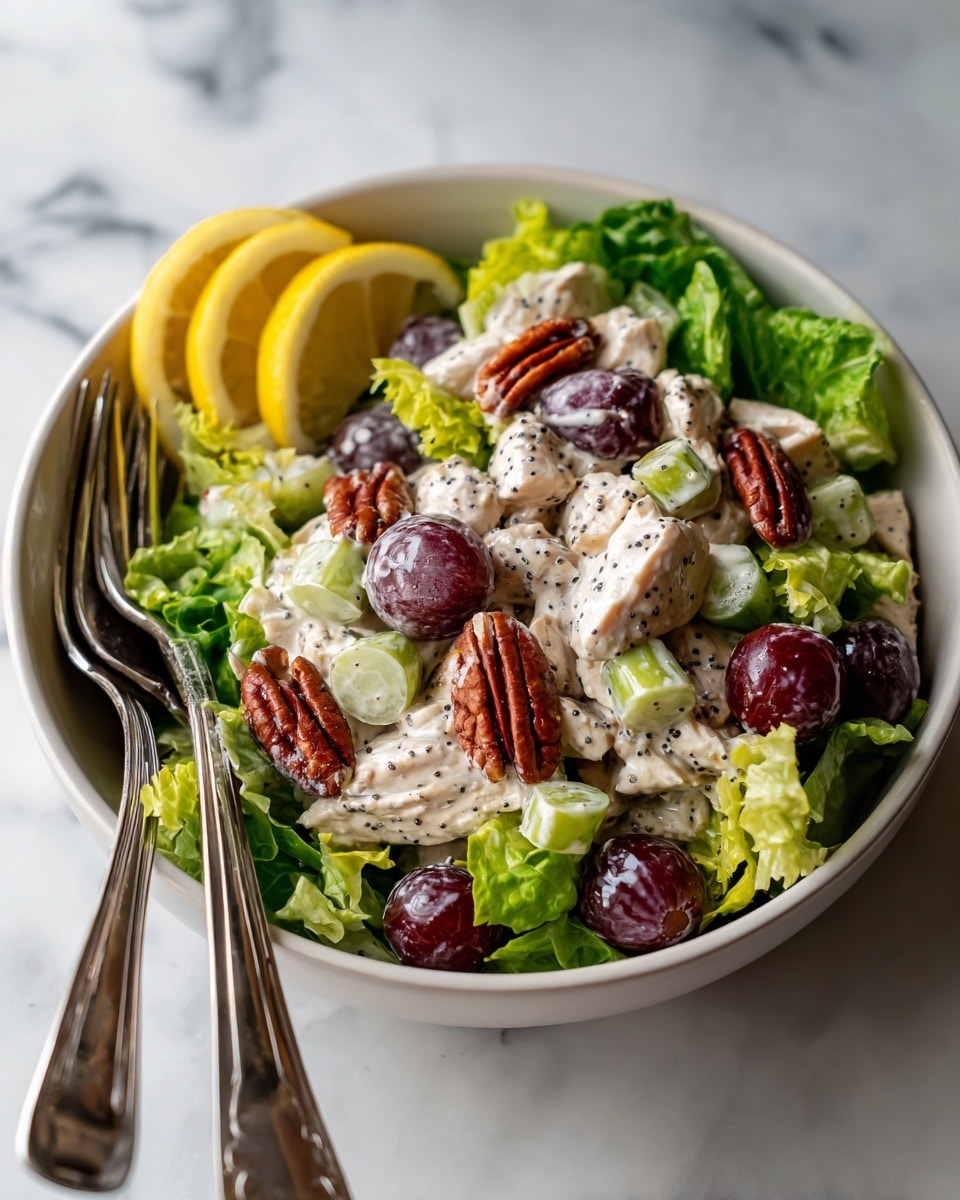 A white bowl filled with a layered salad starting with a base of fresh, bright green leafy lettuce. On top, there is a creamy mixture made of white chicken chunks coated in a light dressing, mixed with halved dark purple grapes, small pieces of light green celery, and scattered pecan halves with reddish-brown shells. Some black poppy seeds are sprinkled over the creamy salad. A couple of light yellow lemon slices rest on the side of the bowl. Two silver forks lie on the left edge of the bowl. The bowl is set on a white marbled surface. Photo taken with an iphone --ar 4:5 --v 7