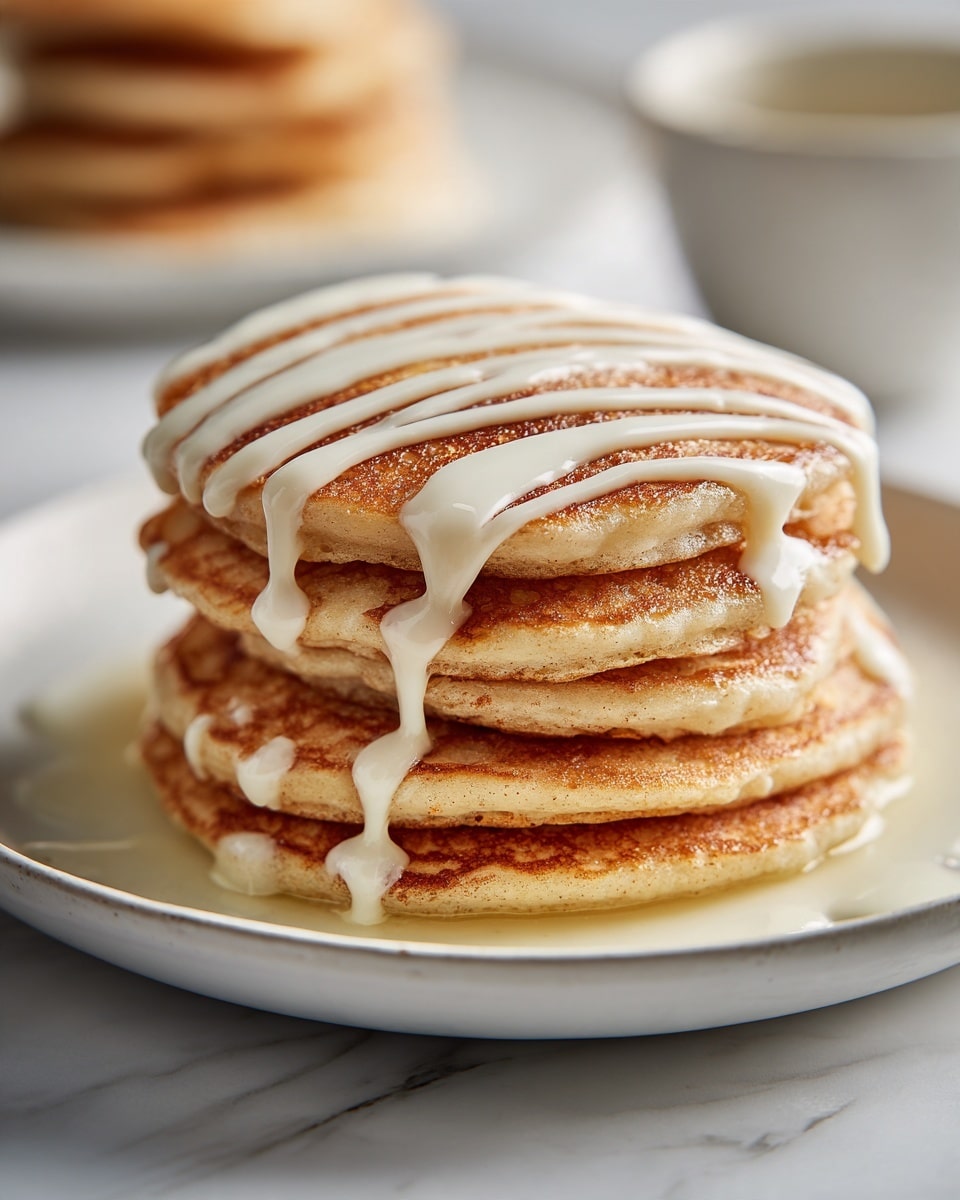 A stack of six thick golden-brown pancakes is placed on a white plate with a subtle speckled edge, sitting on a white marbled surface. The pancakes have a slightly crispy texture on the edges with visible bubbles on the sides. The top pancake is drizzled generously with white creamy icing in thick, uneven lines running horizontally and dripping slightly down the sides. In the background, another similar stack is faintly visible. The lighting is bright and natural, highlighting the warm tones of the pancakes and the creamy icing, giving a fresh and appetizing look. photo taken with an iphone --ar 4:5 --v 7